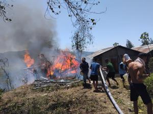 Satgas Pamtas Yonif 742/Swy Memadamkan Kebakaran Di Rumah Warga Perbatasan RI-RDTL