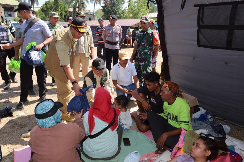 Kepala BNPB Letjen TNI Dr. Suharyanto S.Sos., M.M., (topi hitam rompi cokelat) bersama Menko PMK Pratikno (topi hitam rompi hijau tua) saat berdialog dan menyerahkan bantuan logistik kepada pengungsi terdampak gempa M 7,7 Flores di Lapangan Pendidikan Barangkolong, Kecamatan Reok, Kabupaten Manggarai, NTT, Senin (17/8). (Foto: BNPB)