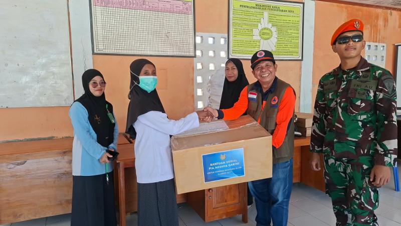 Direktur Penanganan Darurat Wilayah III BNPB, Nelwan Harahap (baju orange rompi) menyerahkan bantuan obat-obatan dan perangkat jaringan telekomunikasi kepada perwakilan tenaga medis serta warga terdampak gempa M 7,7 Flores, di Desa Samporong, Kecamatan Alok, Kabupaten Sikka, Nusa Tenggara Timur, Minggu (23/8). (Foto: BNPB)