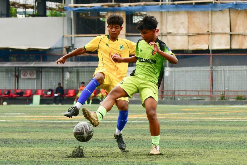 Aksi dua pemain Putra Sejati (kuning) dan Bina Taruna (hijau).foto:pras.